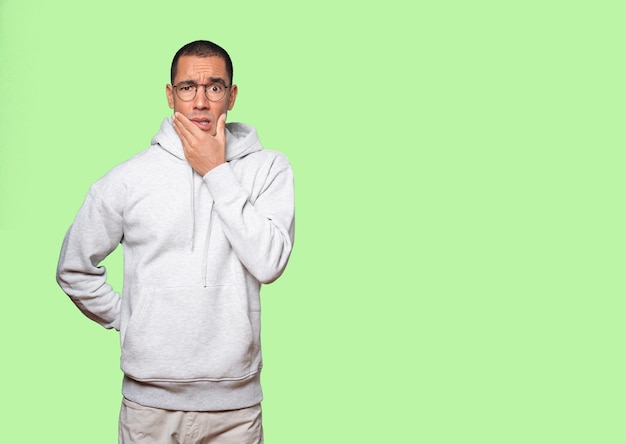 Concerned young man posing against background