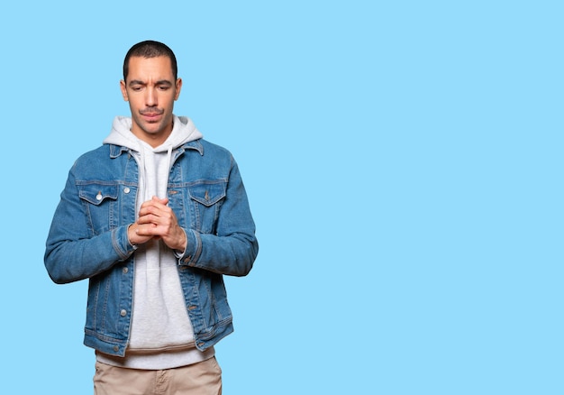 Concerned young man posing against background