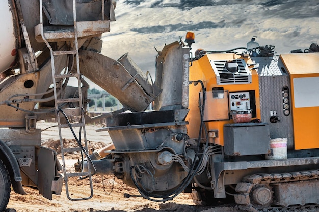 Concrete mixer truck delivers concrete to the pump for pouring piles Concrete pump at the construction site Closeup of concrete delivery