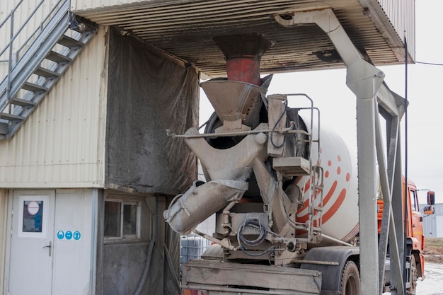 Concrete mixer truck loads concrete at the factory Transportation of concrete to the construction site Construction equipment for the delivery of concrete