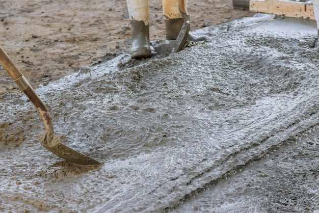 The concrete sidewalk was leveled by the employee using long trowels