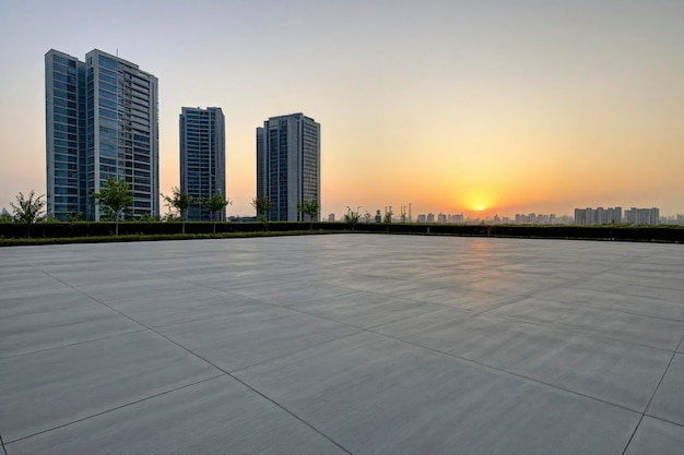 The concrete square floor and the city buildings have a sunset sky background