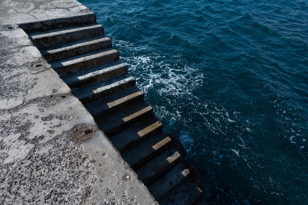 Concrete steps lead to the ocean on a sunny day with shadows Photo minimalism Madeira Island