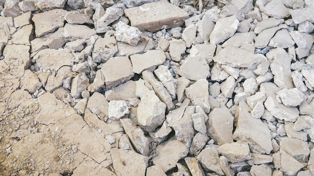 Concrete that is broken into pieces due to the hammering for constructionBackground broken concrete