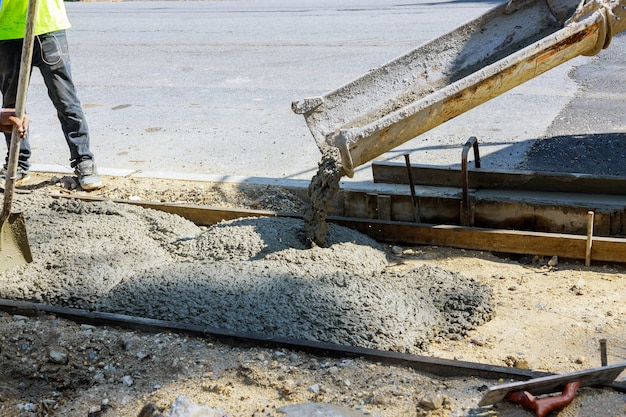 Concrete truck with pouring cement during to residential sidewalk street selective focus