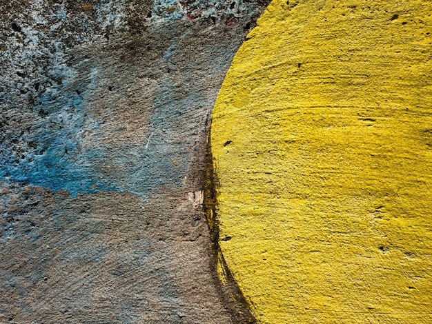 Concrete wall texture painted with blue and brown paint with yellow semicircle Photo