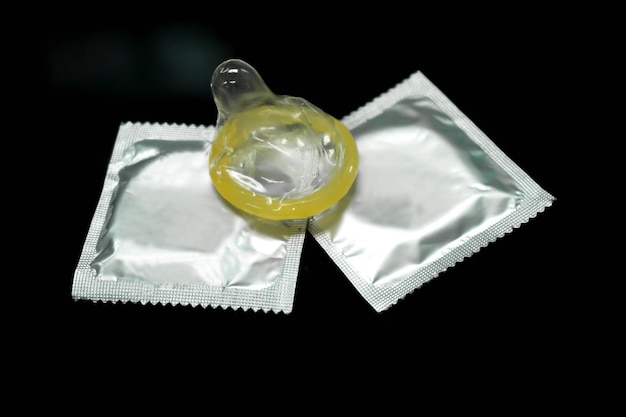 Condom put on silver packages isolate on black background