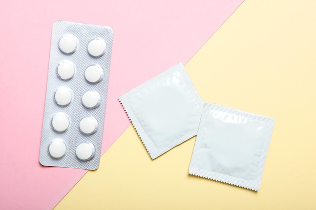 Condoms and other contraceptives on a colored background