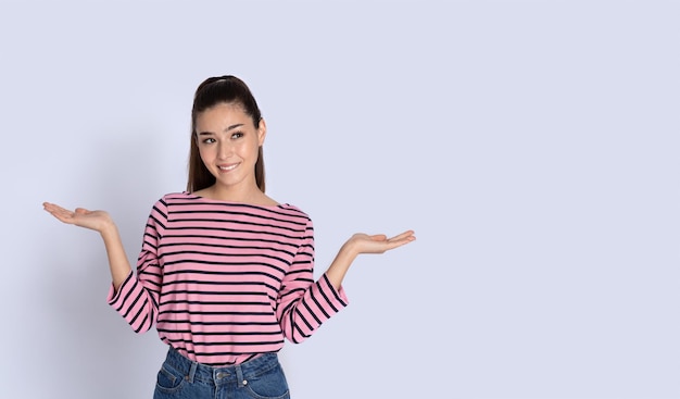 Condused young hispanic woman holding something on her palms