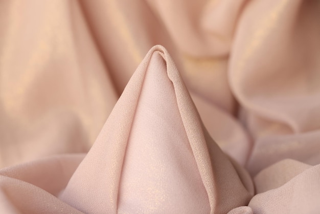 Cone of folded soft pink fabric used for sewing clothes for bed linen store demonstration of