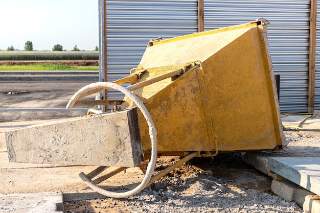 Cone tank for conveying and pouring concrete in monolithic construction by crane.