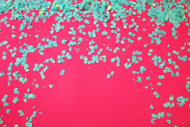 Confetti blue scattered on pink background Carnival party Ad template space Overhead view