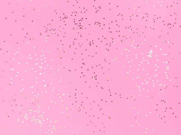 Confetti stars sparkling on a pink background.