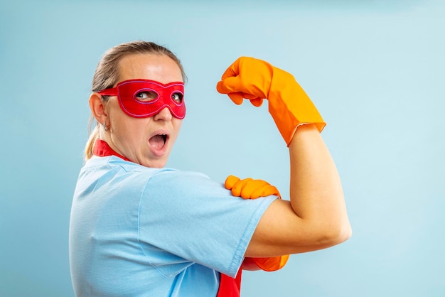 Confidence superhero house cleaner showing her powerful muscle