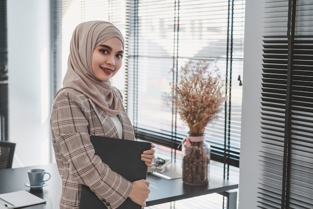 Confident asian muslim business woman brown hijab at modern office.