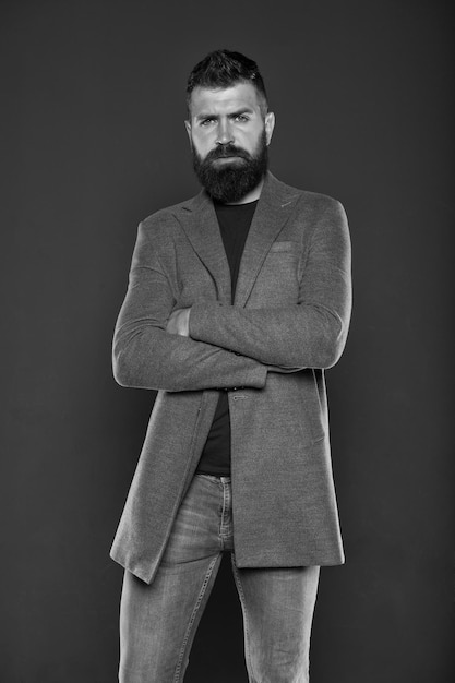 Confident and attractive Confident hipster on grey background Bearded man keeping arms crossed Confident look of fashion model Casual clothing make him feel confident Confidence and self esteem