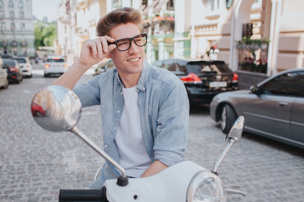 Confident and attractive young man is sitting on motorcycle