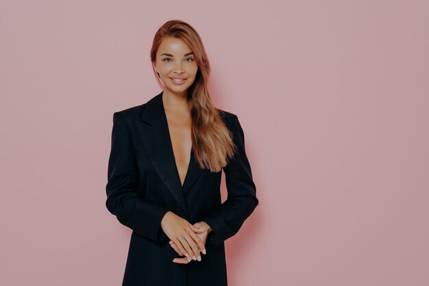 Confident boss lady smiling on pink background