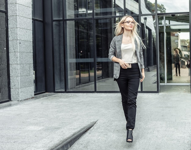 Confident business woman going out from business office