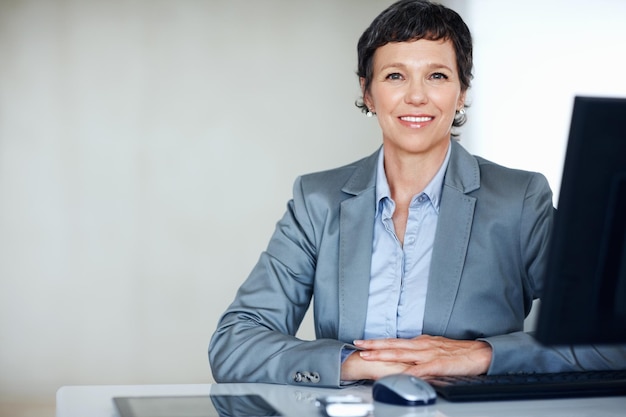 Confident business woman at office Portrait of confident female executive smiling at office desk