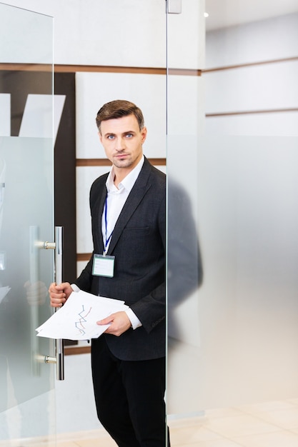 confident businessman in black suit entering the office