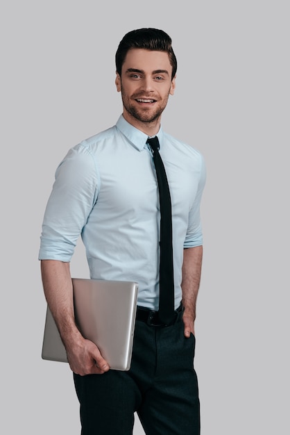 Confident businessman. Businessman posing against the white wall