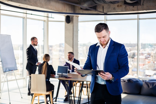 Confident businessman makes a presentation of a new project in the boardroom at a company meeting