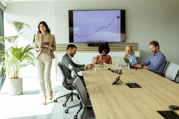 Confident businesswoman leading a strategic meeting in a modern office at midday