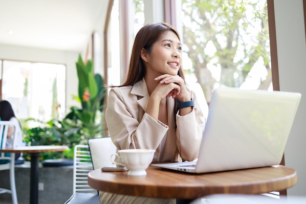 Confident businesswoman smiling and working by laptop in the coffee shop