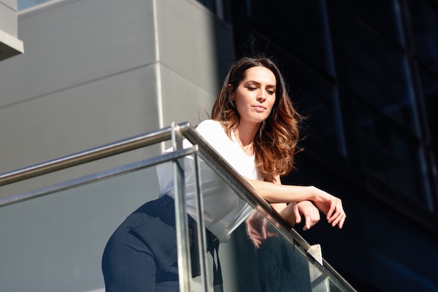 Confident businesswoman standing outside an office building.