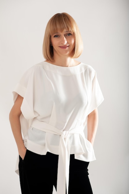 Confident businesswoman in white formal suit on background