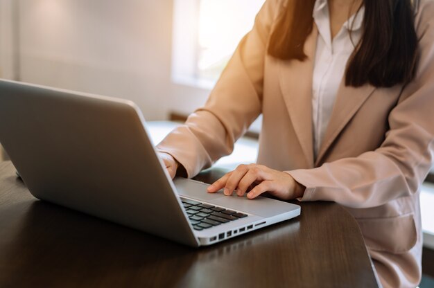 Confident businesswoman working on laptop and tablet at her workplace at modern office.