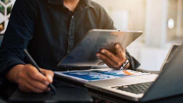 Confident businesswoman working on laptop and tablet at her workplace at officexAxA