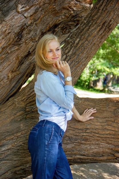 A confident Caucasian girl walks in the park in warm weather outdoors