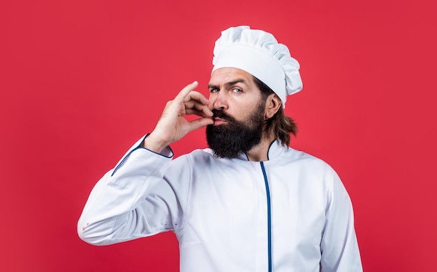 Confident chef man with beard and moustache in cook uniform show sigh of excellence perfect taste