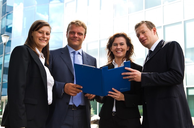 Confident employees discussing document at meeting