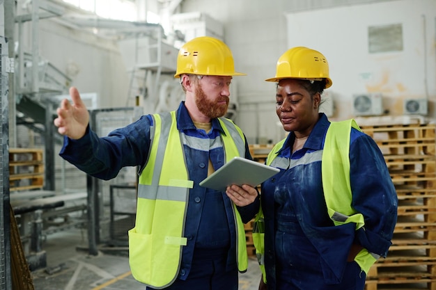 Confident engineer explaining his colleague technical moments of new project