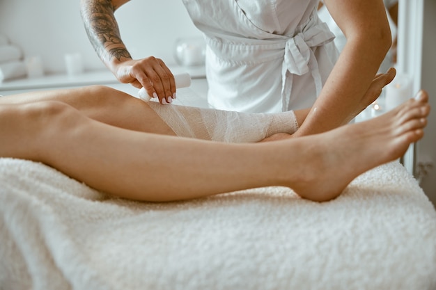 Confident female doctor is doing taping procedure in modenr treatment cabinet