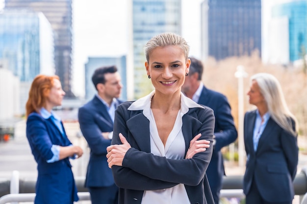 Confident Female Executive with Business Team in Modern Cityscape