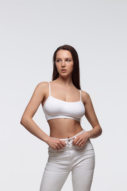 Confident fit lady in seamless bra looking at camera against white background