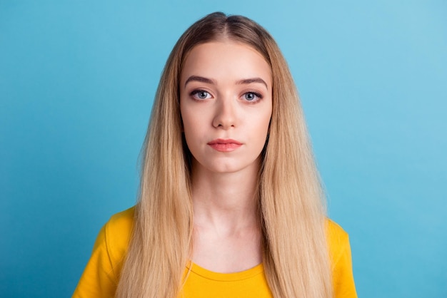 Confident goodlooking woman with blonde hair with healthy pure skin dressed in casual clothes looking seriously at camera