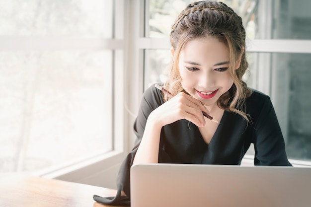 Confident happiness young woman working on laptop or notebook in her office.