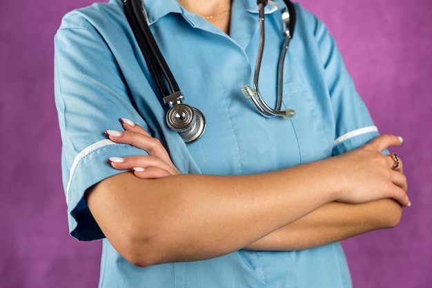 Confident lady doctor in blue uniform putting hand in hand isolated purple color background