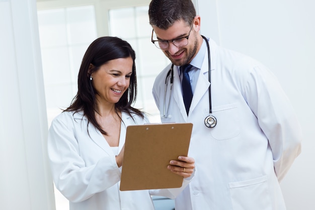 Confident male doctor and his nurse working in the office.