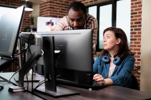 Confident man pointing out mistakes in design blueprint while having conversation with colleague. Creative company digital designer signaling faulty graphic software while in office workspace.