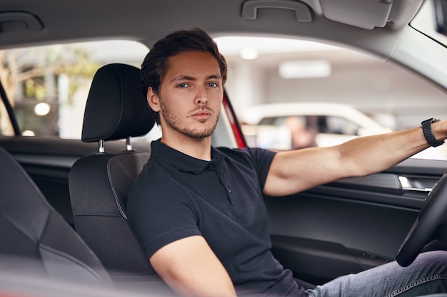 Confident man sitting on driver seat in car