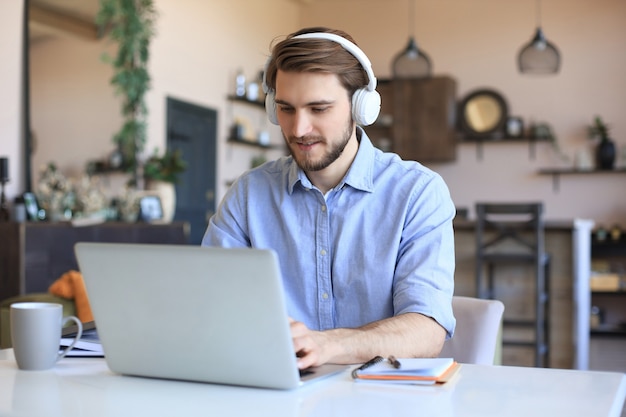 Confident man wearing headset speaking and watching business webinar training, listening to lecture.