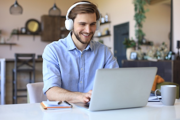 Confident man wearing headset speaking and watching business webinar training, listening to lecture.