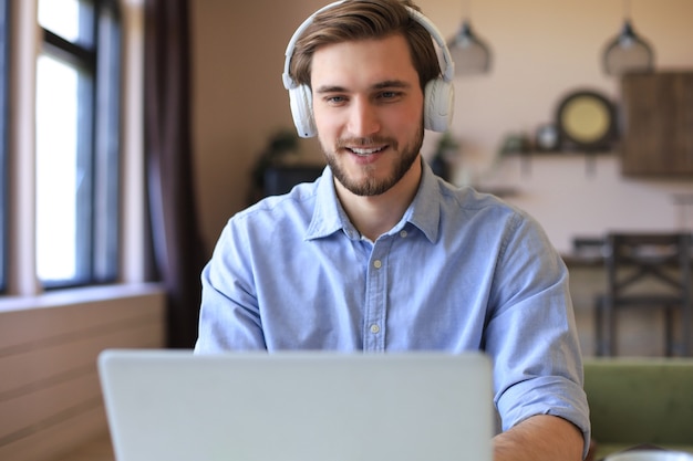 Confident man wearing headset speaking and watching business webinar training, listening to lecture.