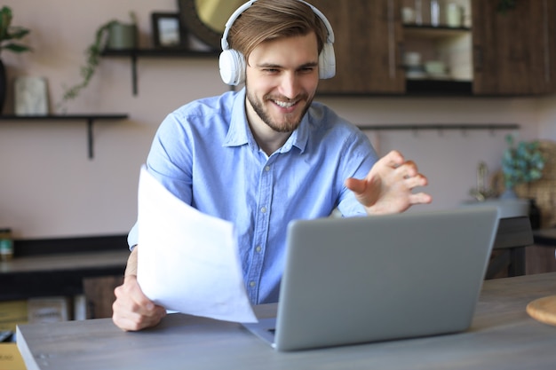 Confident man wearing headset speaking and watching business webinar training, listening to lecture.